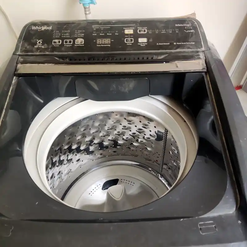Washing machine showing its top controls and open panel